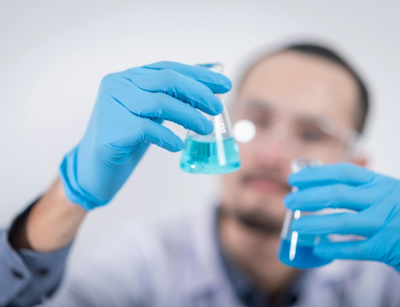 Person Holding Glass Flasks